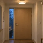 Entré med loftlys, almindelig vægkontakt og diskret bevægelsessensor.