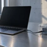 En ubrandet bærbar computer er forbundet med en computerenhed i et gennemsigtigt beskyttelseshus.